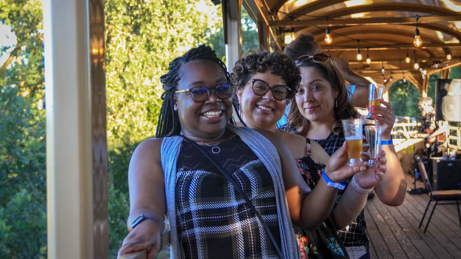 Three friends hollding wine on an open air train